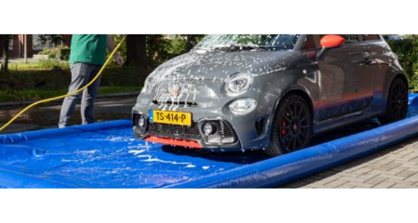 Mężczyzna czyści samochód Abarth w nadmuchiwanej wannie samochodowej